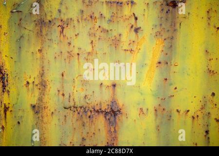 Textur einer Metallwand mit Rissen und Kratzern, die als Hintergrund verwendet werden kann. Peeling geen und gelbe Farbe auf einer Metalloberfläche. Muster. Stockfoto