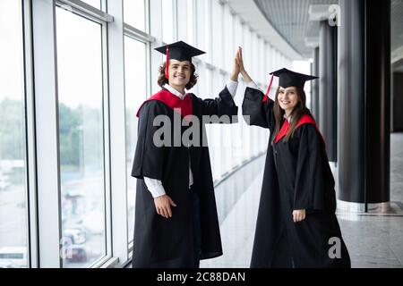 Ein Mann und Frau Paar an der Hochschule Graduierung geben in der Universität Stockfoto