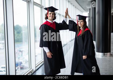 Ein Mann und Frau Paar an der Hochschule Graduierung geben in der Universität Stockfoto