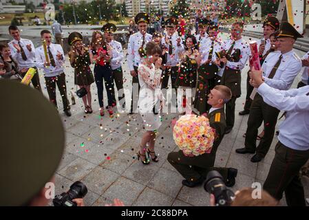 Minsk / Weißrussland - 5. Juni 2019: Junge Erstsemester aus der Militärschule in Uniformen während der Hochzeit Handschlag mit Konfetti Stockfoto