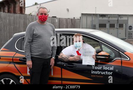 Kyle Duddridge mit seinem Fahrlehrer Dave Gilroy, nachdem er seinen Fahrtest in Liverpool erfolgreich absolviert hat. Die Fahrtests, die im März in ganz Großbritannien ausgesetzt wurden, haben in England mit einem enormen Rückstand wieder aufgenommen, nachdem Hunderttausende von Tests aufgrund der Coronavirus-Sperre verzögert oder abgebrochen wurden. Stockfoto