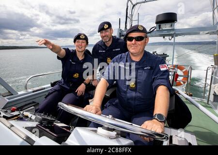 (Von links nach rechts) Kommandierender Offizier LT Rebecca Anderson Royal Navy Abroad HMS Biter mit Senior Naval Officer Nordirland, Commander John Patterson und CPO (ETME) Graeme Hinton am Steuer während Ship's in Company Close-in Manöver entlang der nördlichen Antrim Küste. Die Coronavirus-Pandemie hat logistische Herausforderungen an Bord eines Kriegsschiffs ausgelöst, das die Kommandanten der Zukunft ausbildet. Stockfoto