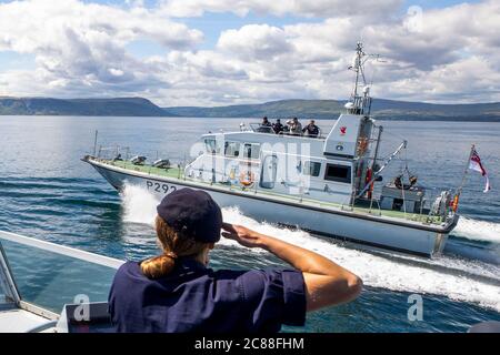 Kommandant LT Rebecca Anderson Royal Navy Abroad HMS Biter begrüßt die Seeleute an Bord von HMS Charger während Ship's in Company Close-in Manöver entlang der nördlichen Küste von Antrim. Die Coronavirus-Pandemie hat logistische Herausforderungen an Bord eines Kriegsschiffs ausgelöst, das die Kommandanten der Zukunft ausbildet. Stockfoto