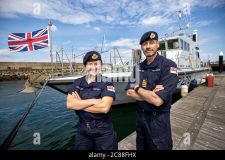 Kommandant LT Rebecca Anderson Royal Navy, und Senior Naval Officer Nordirland, Commander John Patterson, nach Ship's in Company Close-in Manöver entlang der nördlichen Antrim Küste, aufgenommen in Bangor Marina vor HMS Biter stehend. Die Coronavirus-Pandemie hat logistische Herausforderungen an Bord eines Kriegsschiffs ausgelöst, das die Kommandanten der Zukunft ausbildet. Stockfoto