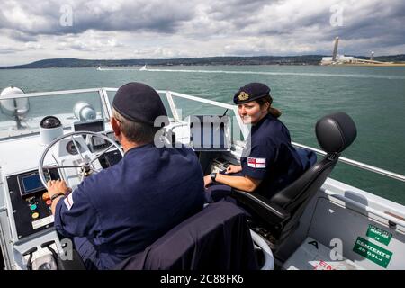 Kommandant LT Rebecca Anderson Royal Navy (rechts) im Ausland HMS Biter mit CPO (ETME) Graeme Hinton am Steuer während Ship's in Company Close-in Manöver entlang der Antrim Küste. Die Coronavirus-Pandemie hat logistische Herausforderungen an Bord eines Kriegsschiffs ausgelöst, das die Kommandanten der Zukunft ausbildet. Stockfoto