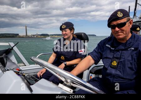 Kommandant LT Rebecca Anderson Royal Navy (links) im Ausland HMS Biter mit CPO (ETME) Graeme Hinton am Steuer während Ship's in Company Close-in Manöver entlang der Antrim Küste. Die Coronavirus-Pandemie hat logistische Herausforderungen an Bord eines Kriegsschiffs ausgelöst, das die Kommandanten der Zukunft ausbildet. Stockfoto