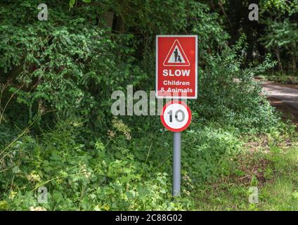 Langsame Kinder und Tiere rote Straßenschild mit einer 10 Geschwindigkeitsbegrenzung Stockfoto