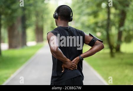 Rückansicht des schwarzen Mannes in Sportkleidung berühren verletzten Rücken Stockfoto