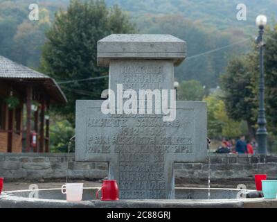 Climanesti, Valcea / Rumänien - 23. Oktober 2019: Antiker Brunnen und auch ein heiliger Brunnen mit Steinkreuz im Kloster Cozia, Rumänien. Stockfoto