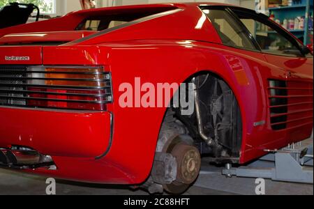 Foto eines Ferrari Testarossa, der mit abgenommenen Rädern aufgebockt wurde. Von hinten rechts fotografiert. Stockfoto