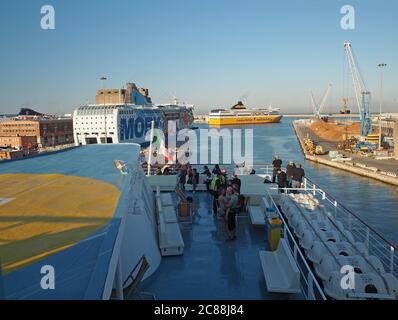 Italien, Livorno, 23. JUNI 2017: Blick von korsischen Linie Fähre Boot mit Menschen an Bord und bunte moby Fähre, Meer Livorno Hafenbank mit Stockfoto