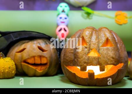 Gruselige benutzerdefinierte seltsame handgemachte orange Kürbis Kopf mit geschnitzten Gesichtern und glühende Kerze oder Licht im Inneren. Halloween Party Dekoration zu feiern Stockfoto