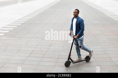 Lächelndes Mädchen mit angenehmen Fahrt auf Elektro-Kick Scooter Stockfoto