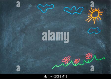 Farbige Kreidezeichnung auf Tafel für das Konzept der Schulrückseite. Draufsicht auf Tafel mit Sonne, Wolken, Blumen, Graszeichnung. Handgezeichnetes Bild Stockfoto