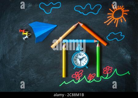 Zurück in die Schule Hintergrund mit farbigen Kreide Zeichnung, Schule aus Bleistiften, Wecker und Papier Flugzeug. Draufsicht der Zeichnung auf Tafel Stockfoto