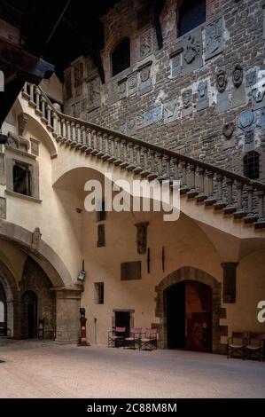 Innenhof der mittelalterlichen Burg der Guidi-Grafen oder Castello dei Conti Guidi in Poppi, Toskana, Italien. Wappen von Familien, die in den 1400s und 1500s Jahren die Region Casentino für Florenz verwaltet haben. Die balustradige Treppe wurde 1477 vom Architekten und Bildhauer Jacopo di Baldassarre Turriani geschaffen, um die oberen Geschichten der ursprünglichen Festung mit ihren späteren Erweiterungen zu verbinden. Die Burg wurde etwa 1274 für Graf Simone di Battifolle, den Chef der Familie Guidi, erbaut. Der letzte Guidi-Graf, Francesco, übergab Poppi 1440 der Florentiner Republik. Stockfoto