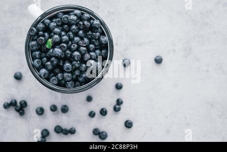 Frische Heidelbeere mit Tropfen Wasser in einer weißen Schüssel. Draufsicht. Konzept der gesunden und Diät Essen. Gesunde Bio saisonalen Obst Hintergrund. Stockfoto