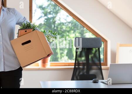 Schöne Geschäftsfrau mit einer Kiste Bürosachen. Neue Arbeitsförderung oder Verlassen des Arbeitskonzepts. Stockfoto
