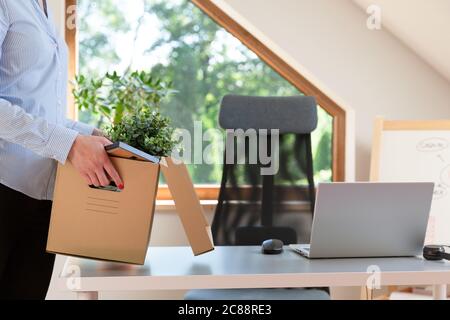 Schöne Geschäftsfrau mit einer Kiste Bürosachen. Neue Arbeitsförderung oder Verlassen des Arbeitskonzepts. Stockfoto