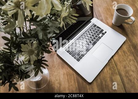 Detailansicht eines bekannten Computerherstellers, geöffnet auf einem Schreibtisch für Heimarbeiter, während der Mitarbeiter nicht am Schreibtisch ist. Stockfoto