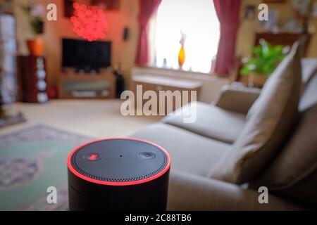 Flacher Fokus eines bekannten, digitalen KI-Personal Assistant in einem Wohnzimmer Ort gesehen. Zeigt den leuchtenden Ring und die Touch-Tasten an. Stockfoto