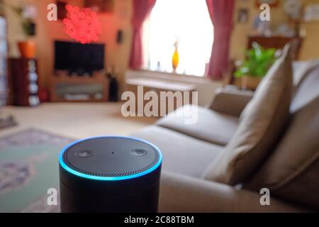 Flacher Fokus eines bekannten, digitalen KI-Personal Assistant in einem Wohnzimmer Ort gesehen. Zeigt den leuchtenden Ring und die Touch-Tasten an. Stockfoto