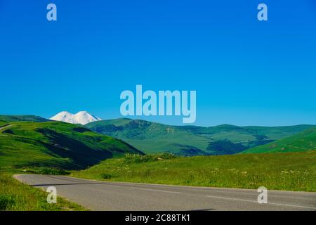 Panorama Road zum Mount Elbrus mit Green Meadows im Sommer. Nordkaukasus, Russland Stockfoto