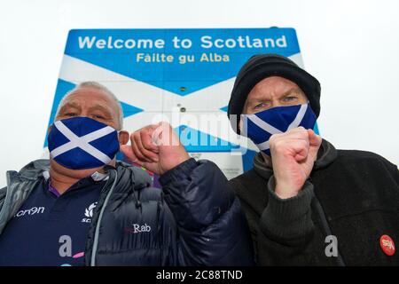 Schottisch/Englisch Grenze in Berwick, Schottland, Großbritannien. 22. Juli 2020 Foto: (L-R) James Connelly; Sean Clerkin von Action for Scotland. Alle Menschen müssen aufhören, von England nach Schottland zu reisen, aus unwesentlichen Gründen, um die schottische Bevölkerung vor Covid-19 zu schützen. Neue Fälle von Covid-19 sind 5.5-mal höher in England als Schottland und Professor Rowland Kao ein mathematischer Biologe an DER UNIVERSITÄT EDINBURGH erklärte kürzlich, dass, wenn es erhöhte Reisen zwischen England und Schottland ist es unvermeidlich, dass Fälle von Covid-19 wird in Schottland zunehmen. Quelle: Colin Fisher/Alamy Live News. Stockfoto