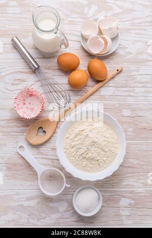 Auswahl an Backzutaten für Kuchen oder Pfannkuchen auf Holzboden Stockfoto