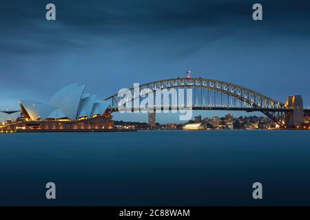 Blick in die Dämmerung auf das Opernhaus von Sydney und die Sydney Harbour Bridge, vom Mrs Macquaries Point aus gesehen. Stockfoto