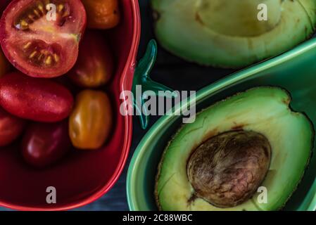 Zwei Schalen, die für Tomaten und Avocados auf einem Tisch angepasst sind Stockfoto
