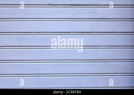 Kontrastarme Struktur einer Holzwand, weiß-blaue Färbung. Ein Gebäude mit hellblauen Holzplanken, abstrakte Textur für Hintergrund. Stockfoto