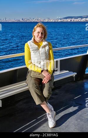 Eine junge Kaukasierin ruht auf dem Deck eines Schiffes, das Passagiere zu den Prinzeninseln von Istanbul am Marmarameer, einem sonnigen wik, bringt Stockfoto