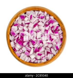 Rote Zwiebeln in Würfel geschnitten in Holzschüssel. Würfel der Zwiebelsorte Allium cepa schneiden, mit violettroter Haut und weißem Fruchtfleisch, das mit Rot gefärbt ist. Nahaufnahme, von oben. Stockfoto