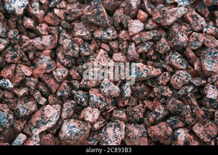 Abstraktes Bild eines Schutthaufens aus rosa Granit. Material für die Konstruktion. Stockfoto