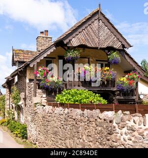 Ein Schweizer Chalet-Balkon auf einem alten Steinhaus im Exmoor Nationalpark im Dorf Bossington, Somerset UK Stockfoto