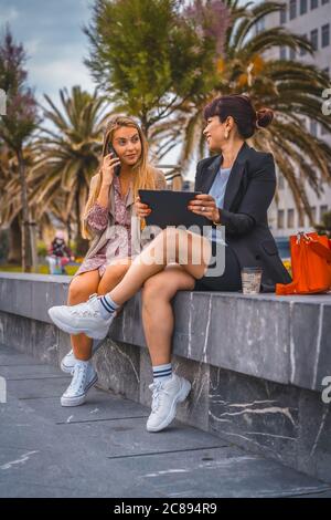 Vertikale Aufnahme von zwei jungen hispanischen Unternehmerinnen außerhalb der Büro in Arbeitspause Stockfoto