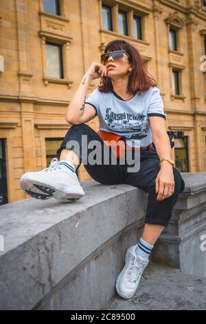 Vertikale Aufnahme einer jungen hispanischen Brünette weiblich tragen modisch Kleidung in der Stadt Stockfoto