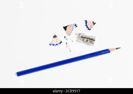 Bleistift und Spitzer auf weißer Papieroberfläche Stockfoto