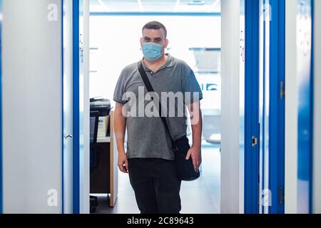 Mollige Patient trägt Gesichtsmaske verlassen eine medizinische Beratung Stockfoto