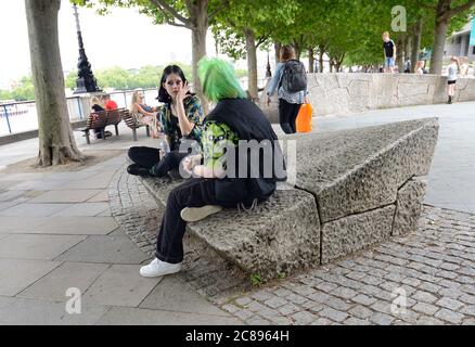 London, England, Großbritannien. Zwei junge Frauen im Gespräch auf der Südbank, eine mit grünem Haar Stockfoto