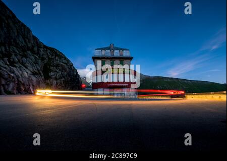 Langtexpossure des vorbeifahrenden Autos in einem Hotel an einer schweizer Alpenpassstraße Stockfoto