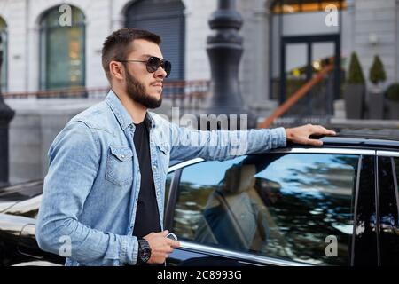 Junge intelligente Kerl wartet auf seine Freundin auf der Straße. Datum Konzept. Seitenansicht Foto Stockfoto