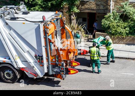 Mitarbeiter des Stadtrats von Islington, die grünen Abfall in einen LKW zum Recycling und Kompostieren entleeren, London, Großbritannien Stockfoto