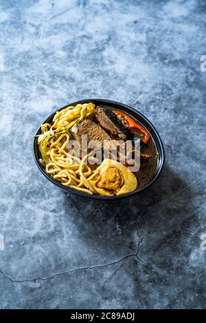 Shoyu Ramen Nudel mit Ei, Sojabohnen, Kalbsfleisch, Karotten, Zwiebeln, Algen Wakame, Japanischen Radieschen und Sojasauce. Gesunde Traditionelle Fast Food. Stockfoto