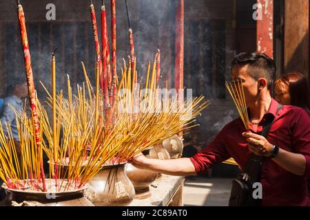 Der Mensch verbrennt Räucherstäbchen als Opfergabe in Vietnam Stockfoto