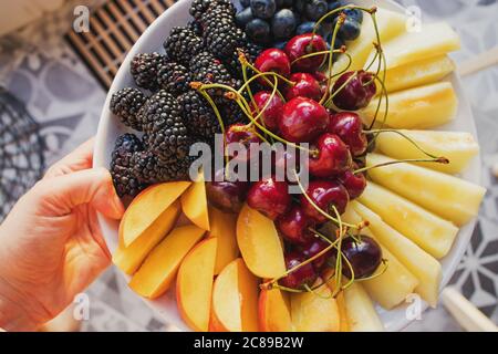 Nahaufnahme des Tellers mit saftigen Sommerfrüchten und Beeren. Stockfoto