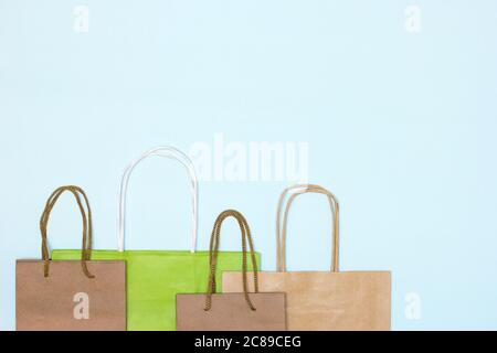 Bastelpapier Merchandise Taschen auf pastellblauem Hintergrund. Speicherplatz kopieren. Shopping, Verkauf minimales Konzept Stockfoto