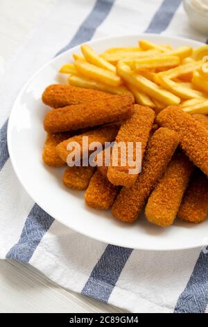 Hausgemachte Fischstäbchen und Pommes mit Tatarensauce, Seitenansicht. Stockfoto