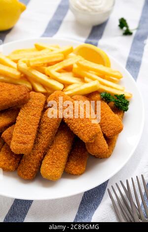 Hausgemachte Fischstäbchen und Pommes mit Tatarensauce, Seitenansicht. Stockfoto